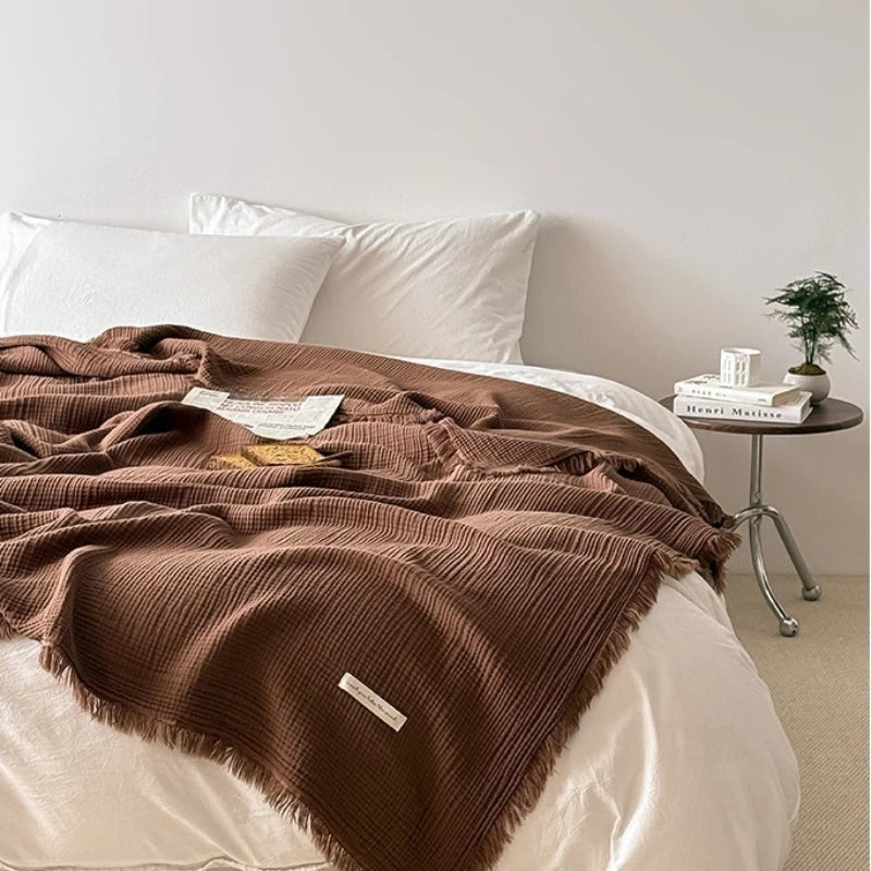 Cobertor de gaze 100% algodão com franjas sobre a cama, cor café