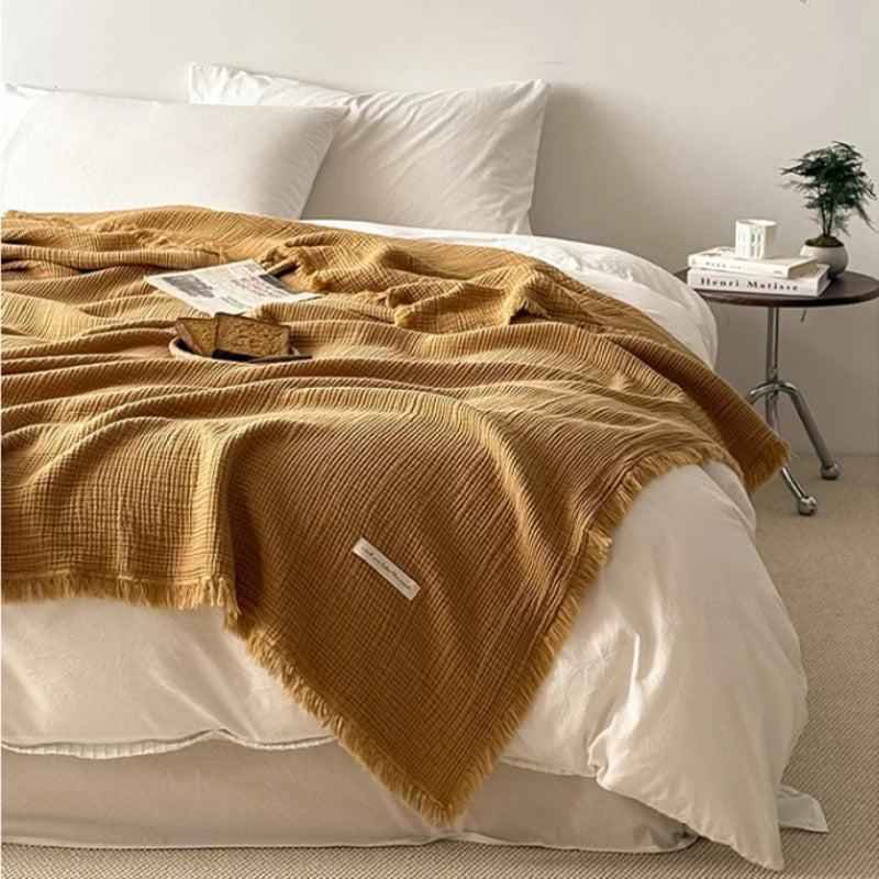 Cobertor de gaze 100% algodão com franjas sobre a cama, cor camelo